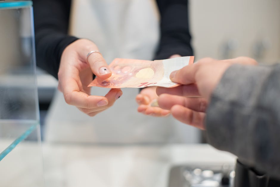 Close interaction of hands exchanging cash in a café setting. Business transaction detail.