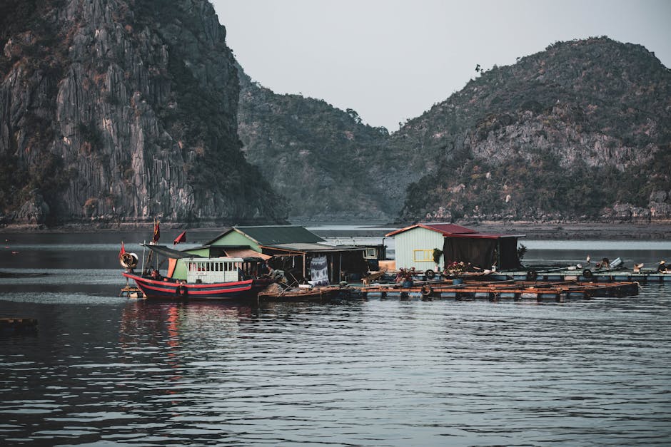 A traditional fishing boat and floating village in the serene waters of Ha Long Bay, Vietnam.